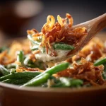 Close-up of a creamy green bean casserole in a crockpot, garnished with crispy fried onions.