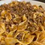 Close-up of a creamy beef and noodle dish with a side view showcasing the juicy texture.