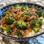 Close-up view of a dish featuring ground beef and broccoli, with visible grains of brown sugar and sesame oil glistening.