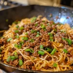 Close-up view of Ground Beef Mongolian Noodles with fresh green onions.
