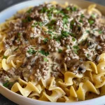 Close-up view of a creamy Ground Beef Stroganoff served on a plate with egg noodles.