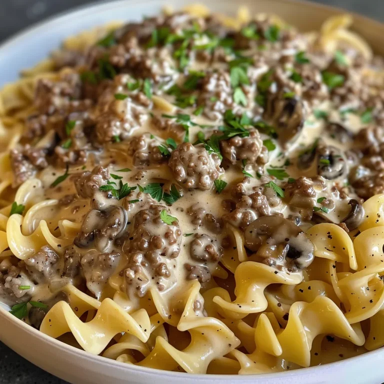 Close-up view of a creamy Ground Beef Stroganoff served on a plate with egg noodles.