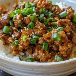 A close-up view of a bowl of Honey Garlic Ground Turkey, glistening with sauce.