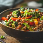 A close-up of a Spicy Ground Beef Stir-Fry Bowl featuring colorful vegetables and rice.