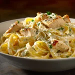 Close-up of creamy Cajun chicken pasta topped with parmesan, illuminated by soft natural light.