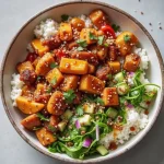 A close-up of a Spicy Hot Honey Chicken Bowl featuring colorful vegetables and a glossy honey drizzle.