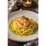 Close-up of a luxurious Butter Poached Lobster Pasta dish with vibrant herbs and creamy sauce.
