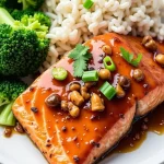 Close-up shot of a glazed honey garlic soy salmon fillet garnished with green onions.