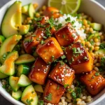 Close-up of a honey glazed salmon rice bowl with steamed broccoli and julienned carrots.