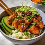 Close-up shot of a honey garlic salmon rice bowl featuring salmon fillets, cooked rice, and steamed broccoli.