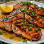 Close-up of Honey Garlic Grilled Salmon fillet garnished with green onions.