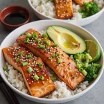 Close-up of a Honey Garlic Salmon Rice Bowl with salmon, rice, broccoli, and carrots.