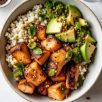 Close-up of a Honey Glazed Salmon Bowl with salmon, quinoa, broccoli, and avocado.