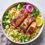 Close-up of a vibrant Sunshine Salmon Couscous Bowl featuring salmon, couscous, and fresh vegetables.