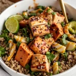 Close-up of a Maple Dijon Chicken & Pear Bowl featuring chicken thighs, sweet potatoes, and avocado.