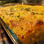 Close-up of a golden-brown cornbread squash casserole with visible yellow squash slices.