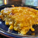 Close-up of a cooked corn casserole in a crockpot, showcasing a golden-brown, slightly crusty top.