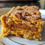 Close-up view of a slice of Pumpkin Pie Dump Cake with a golden crust and creamy filling.