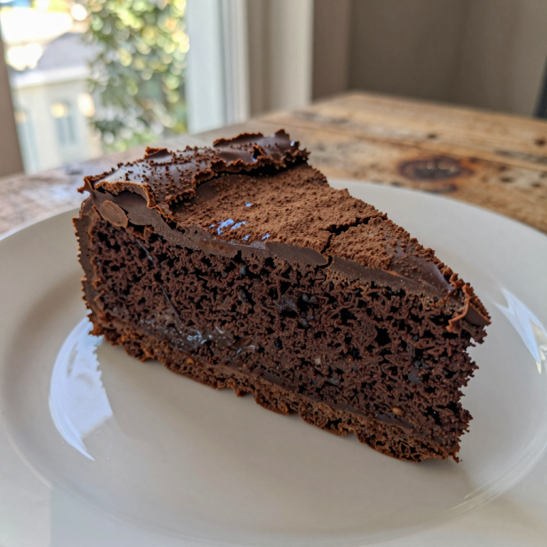 Rich, dark flourless chocolate cake on a rustic wooden surface.