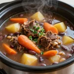 A steaming bowl of slow cooker oxtail soup garnished with fresh herbs