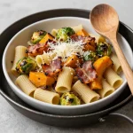 A plate of pasta topped with roasted Brussels sprouts and butternut squash