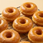 A plate of freshly baked gluten-free pumpkin donuts topped with cinnamon sugar